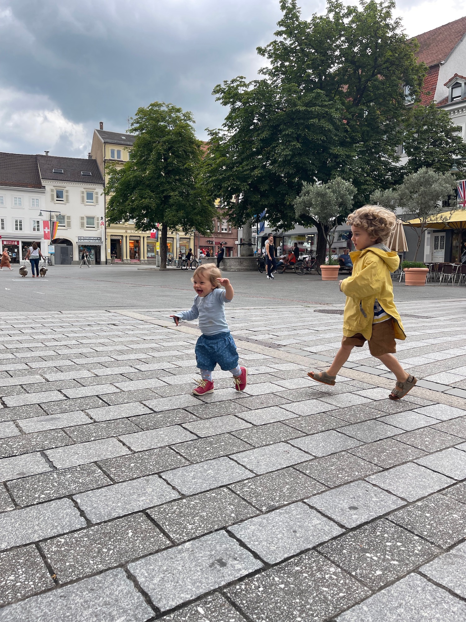 two children running on a stone walkway