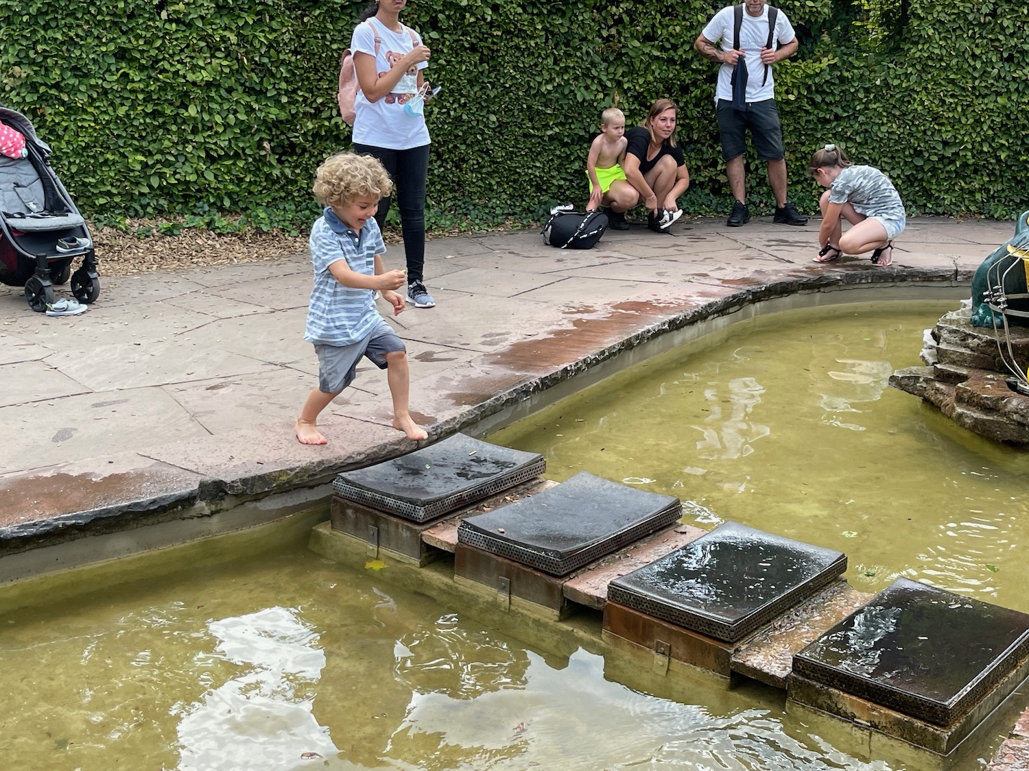 a group of people standing next to a pond