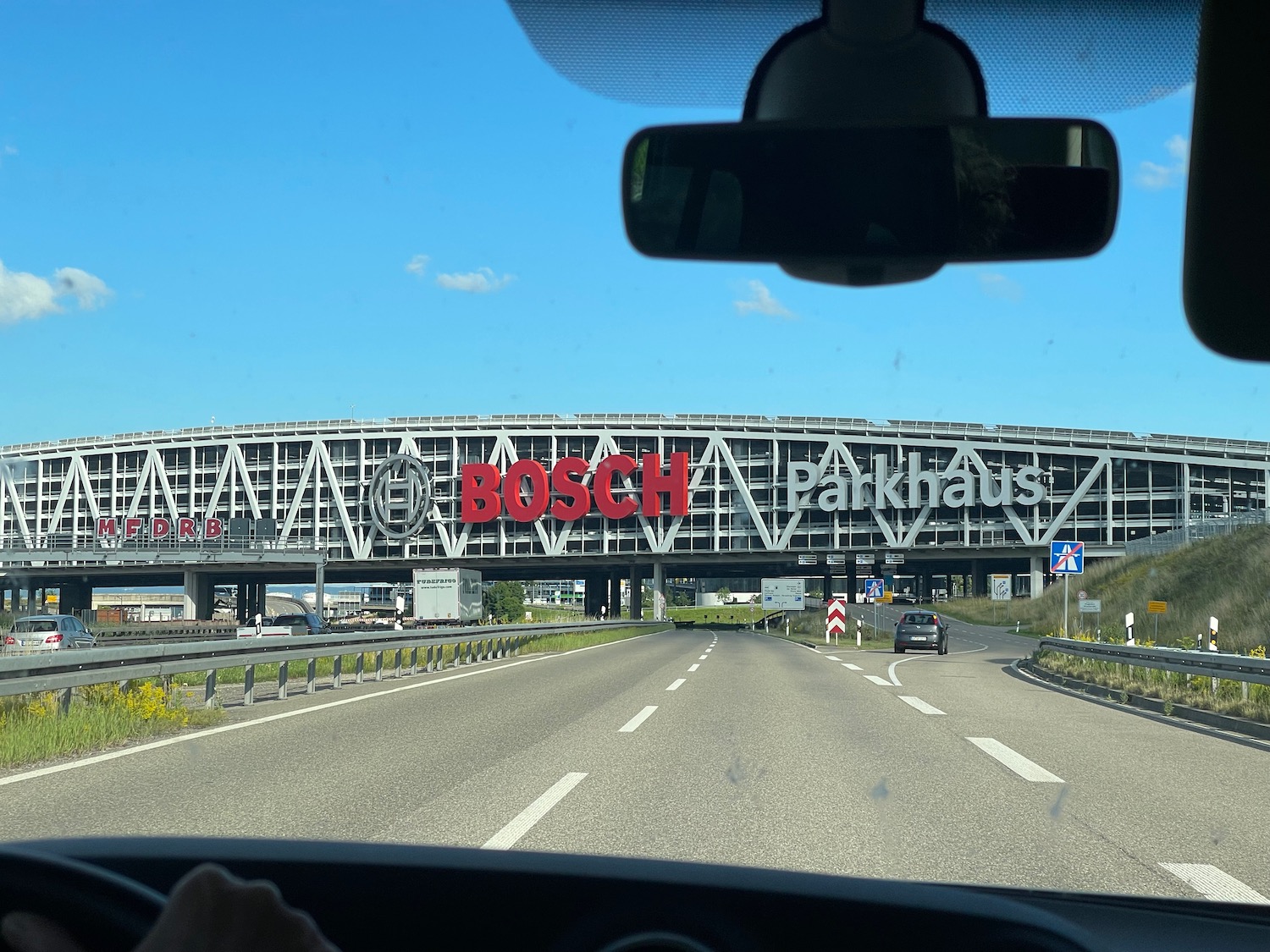 a view from a car window of a car on a highway with a large building