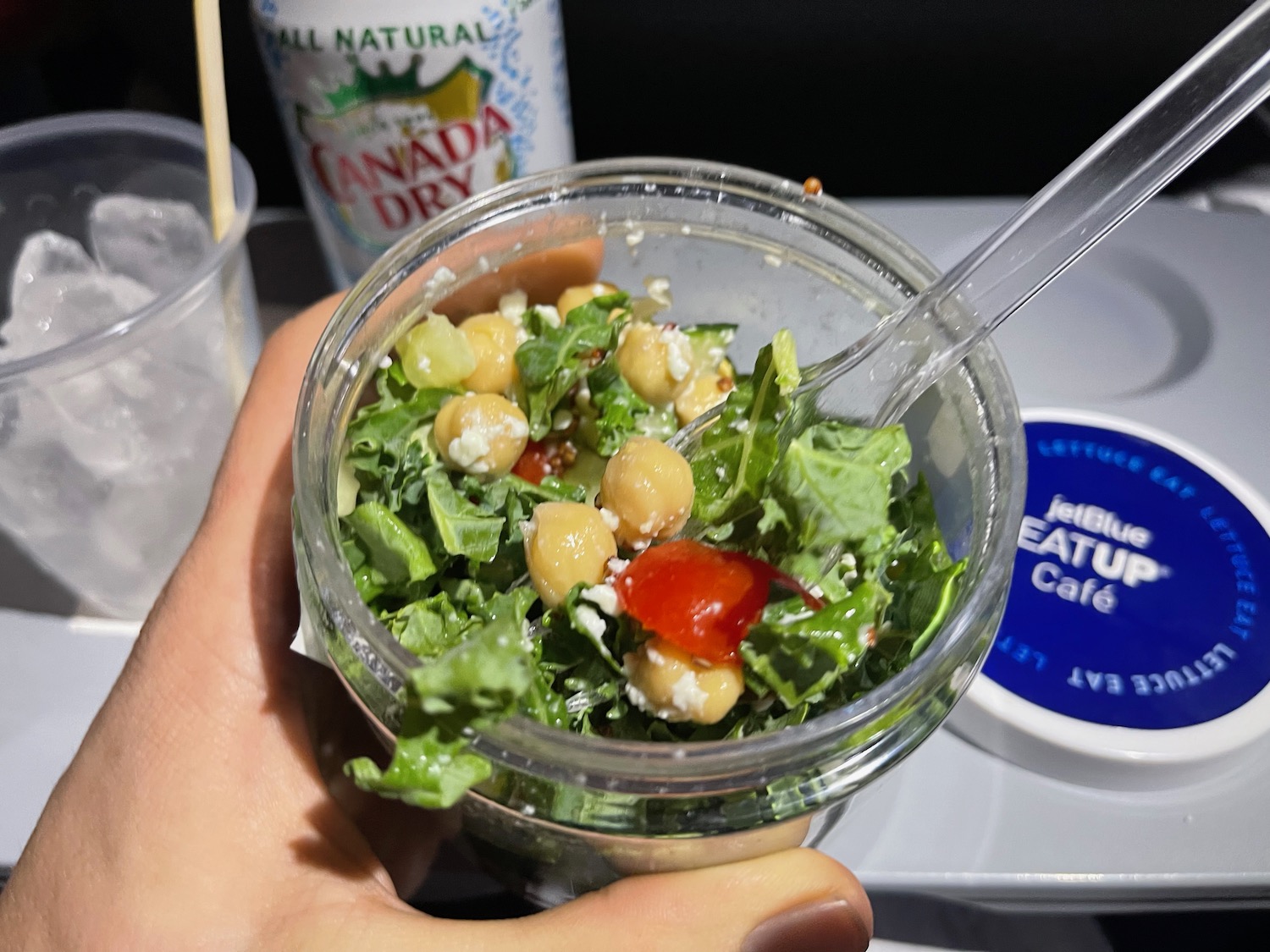 a hand holding a bowl of salad