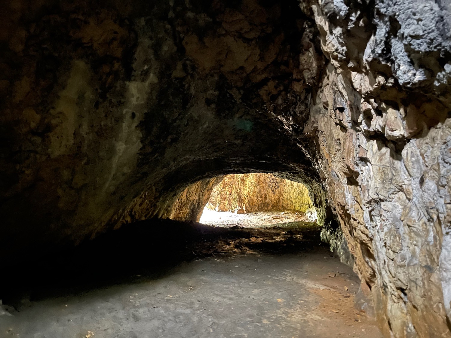 a cave with a light in the tunnel