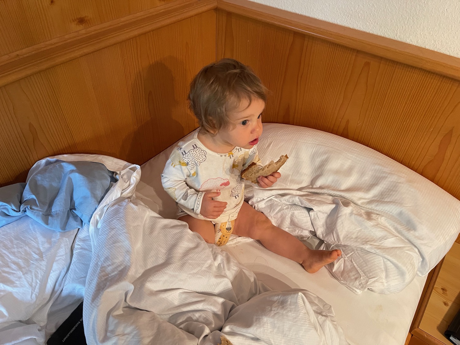 a baby eating food on a bed