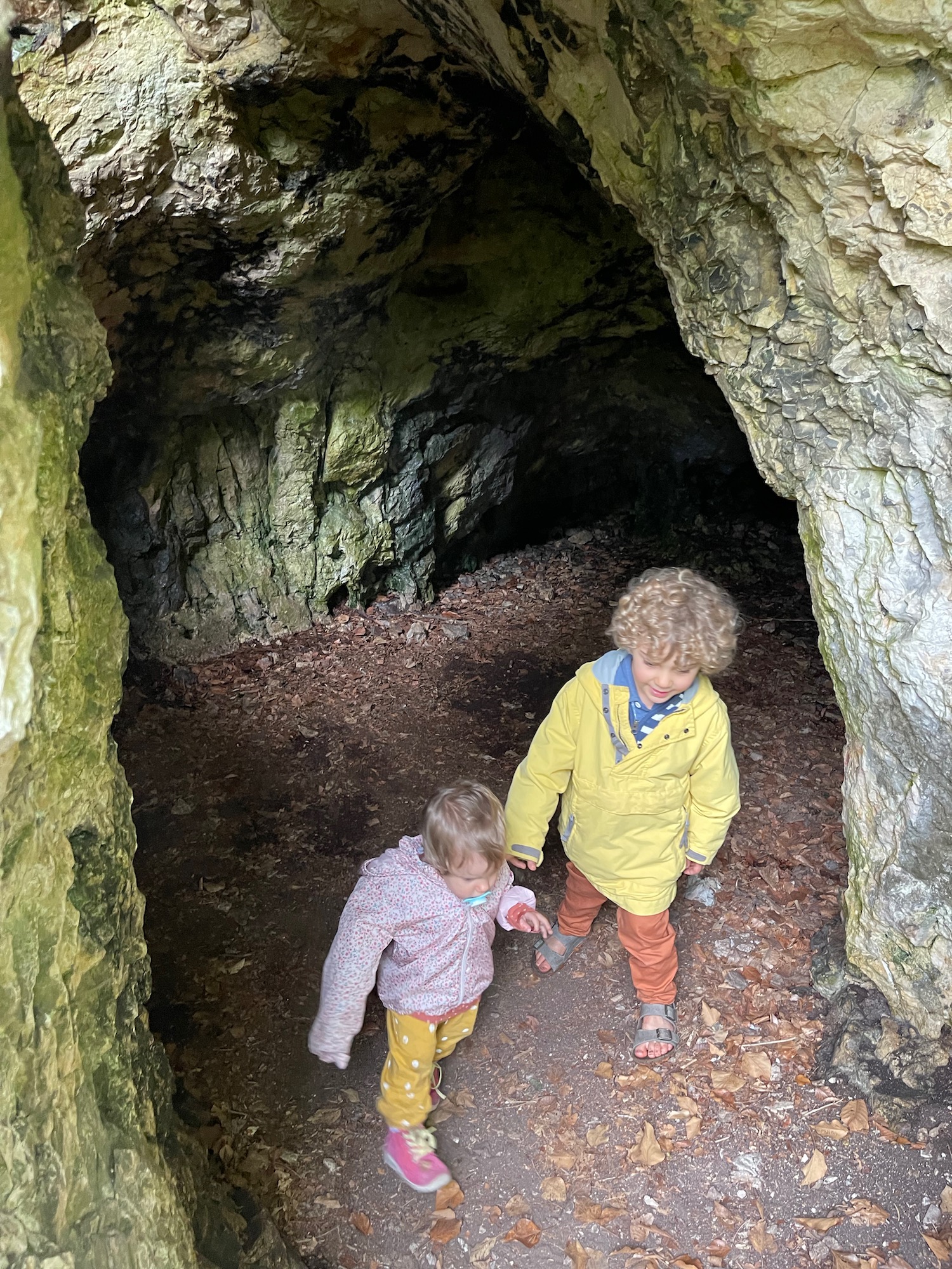 two children walking in a cave