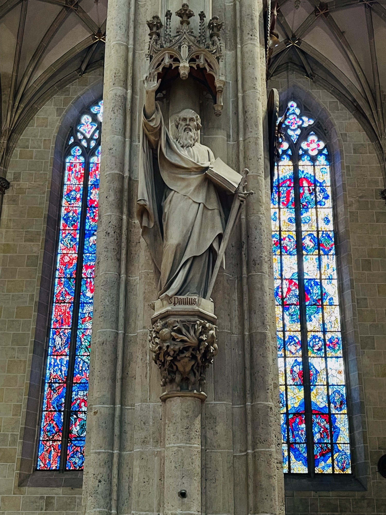 a statue of a man holding a book and a sword in a church