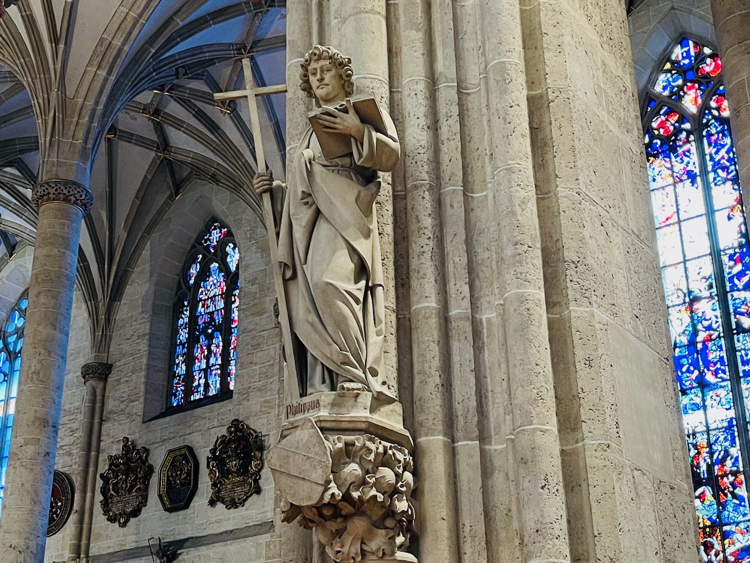 a statue of a man holding a cross and a book