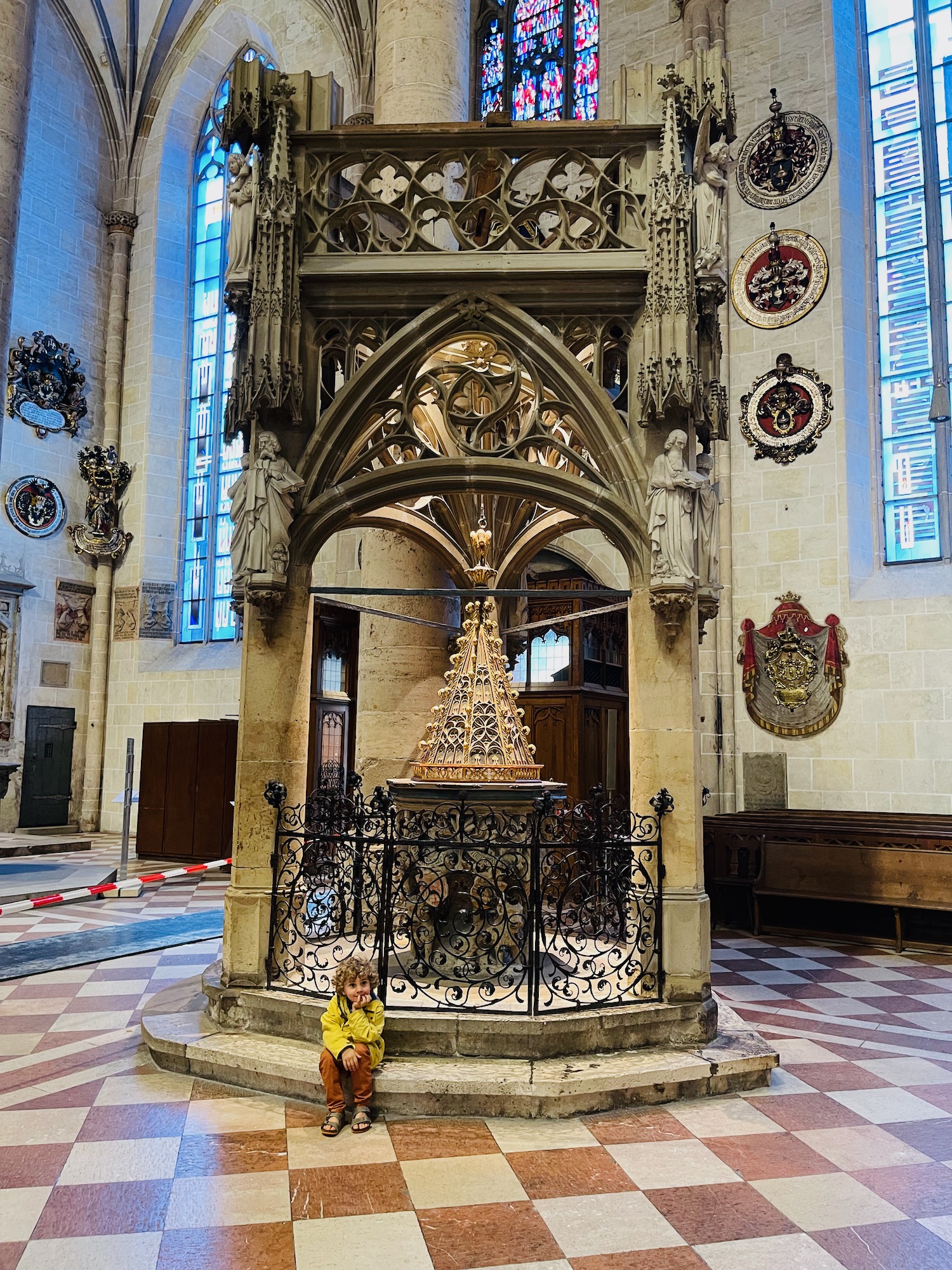 a child sitting on a stone pedestal in a church