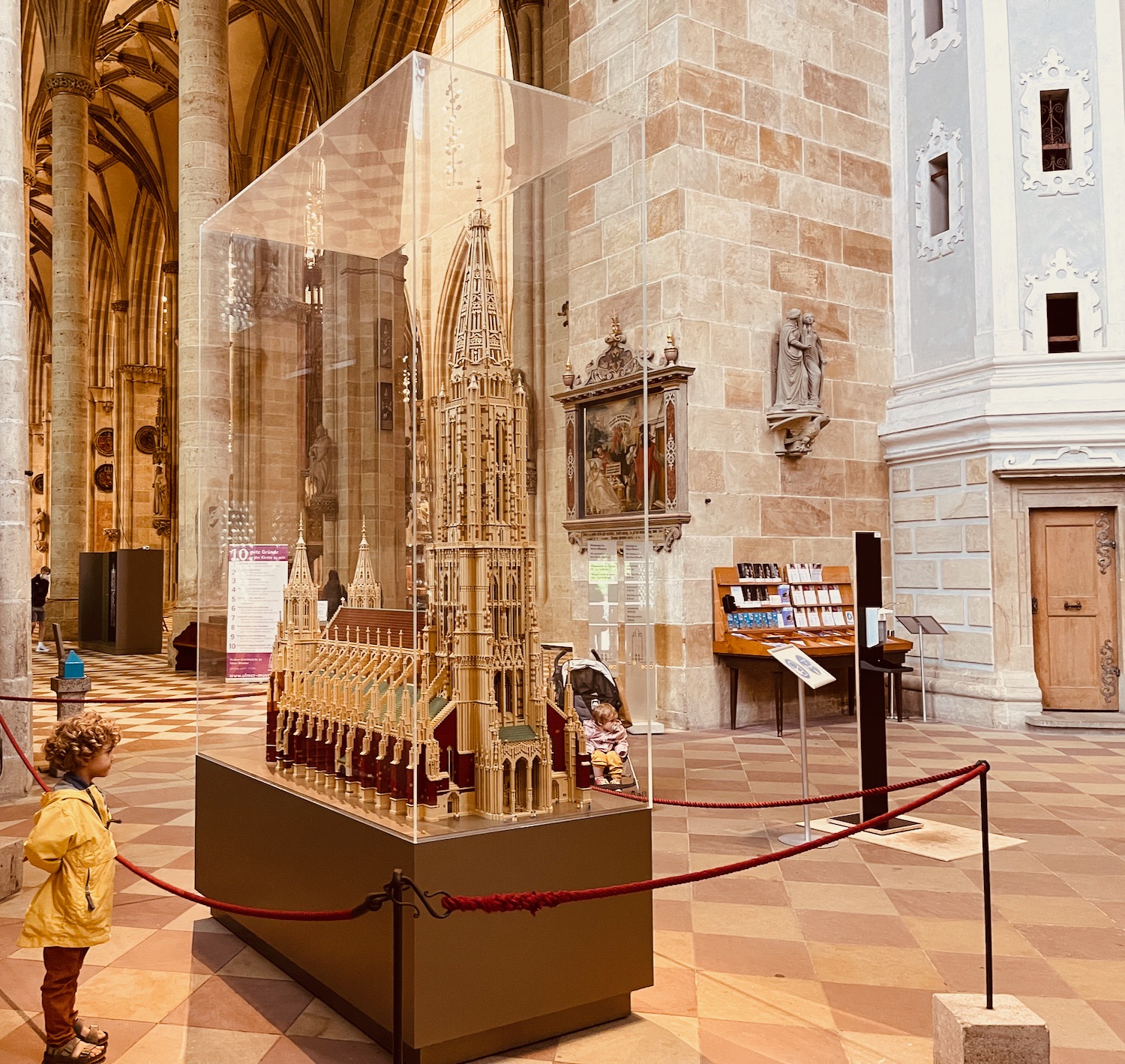 a child looking at a glass case in a large building