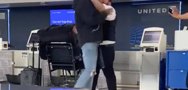 two men hugging in an airport