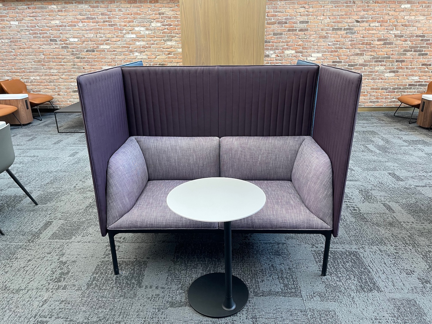 a couch with a table in front of a brick wall