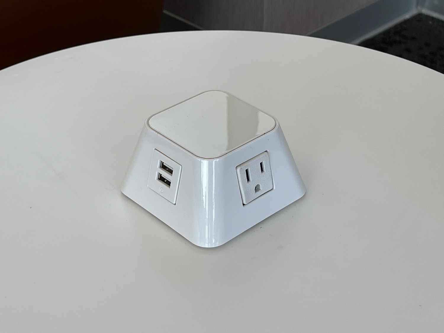a white square outlet with usb ports on a white table