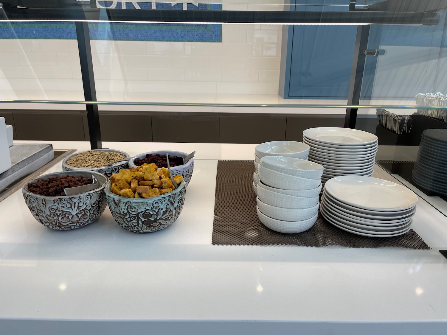 a buffet with bowls of cereal and plates