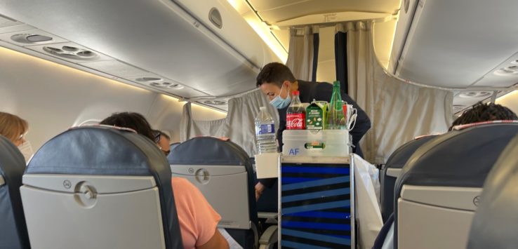 a man wearing a face mask and sitting in an airplane