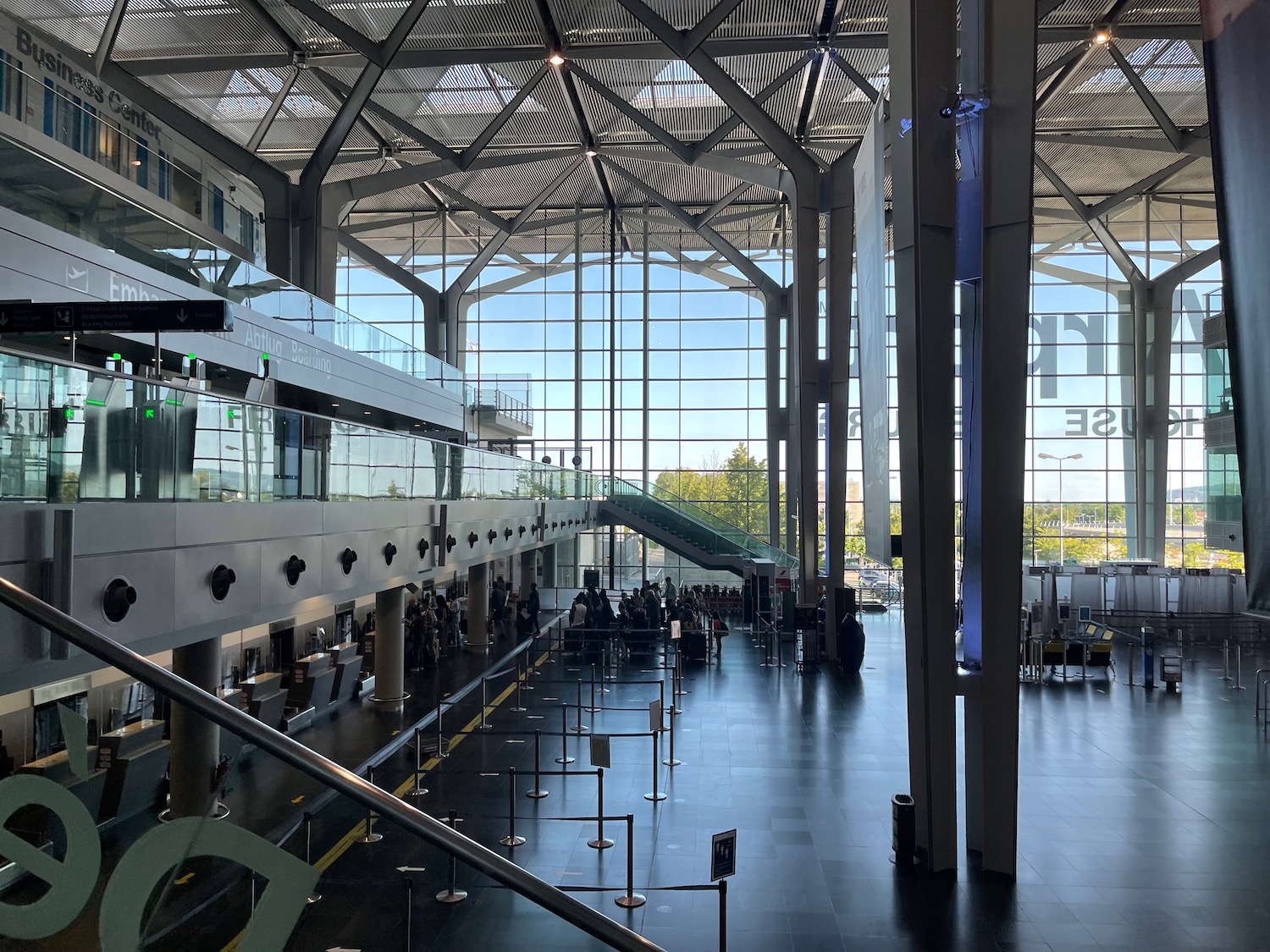 a large glass building with a staircase and people walking