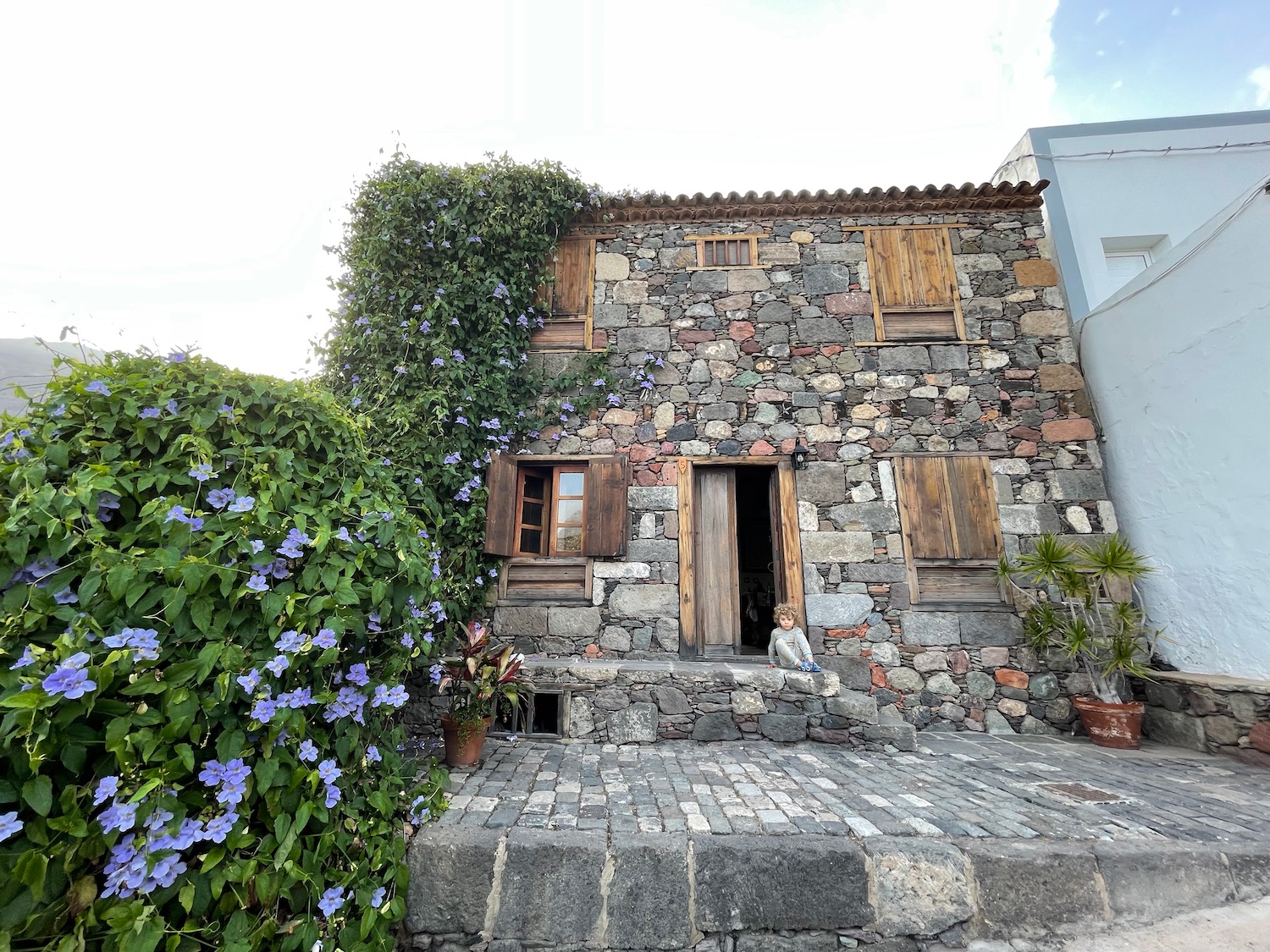 a stone building with a stone wall and a stone walkway