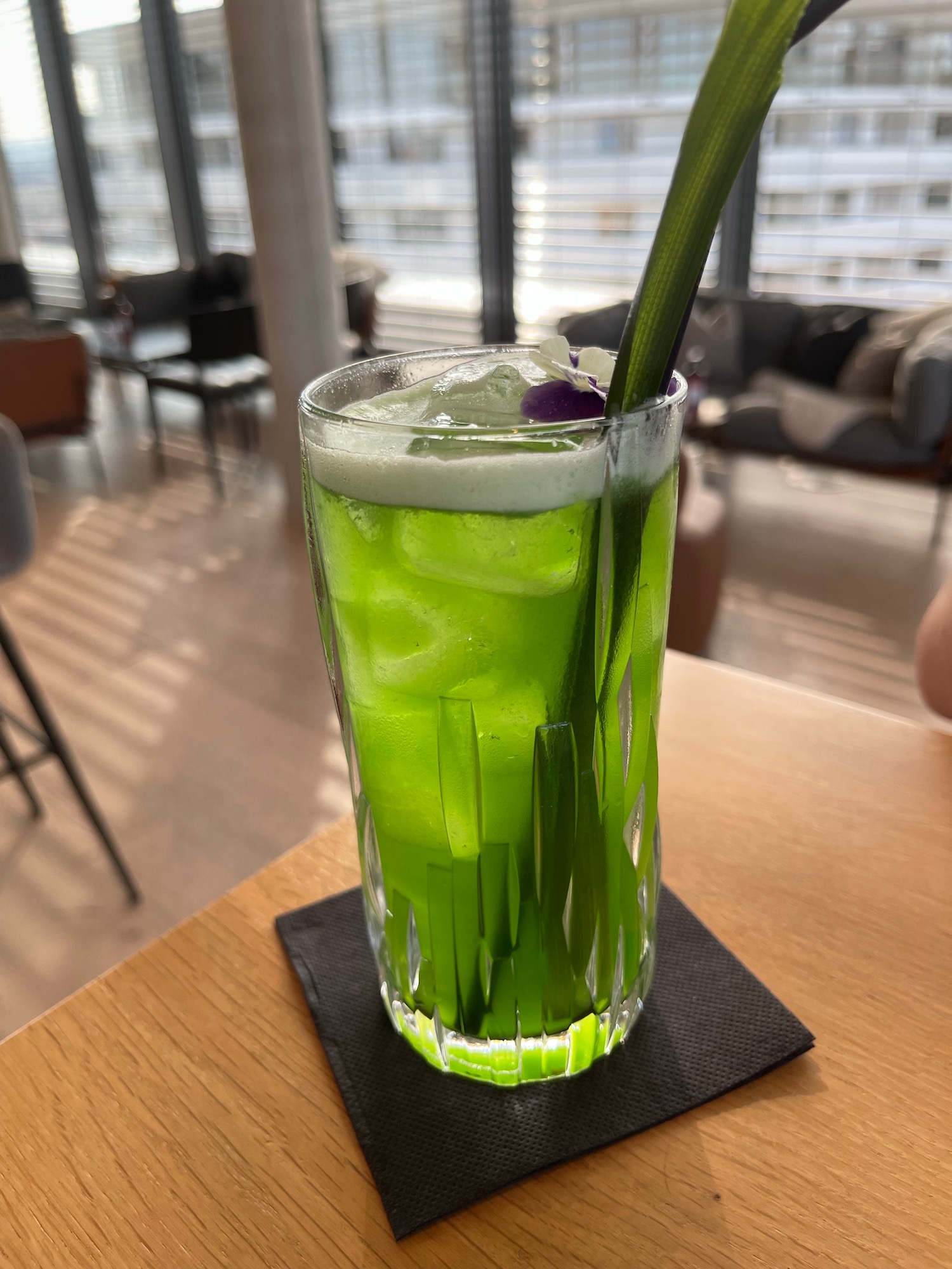 a glass with green liquid and a stem in it