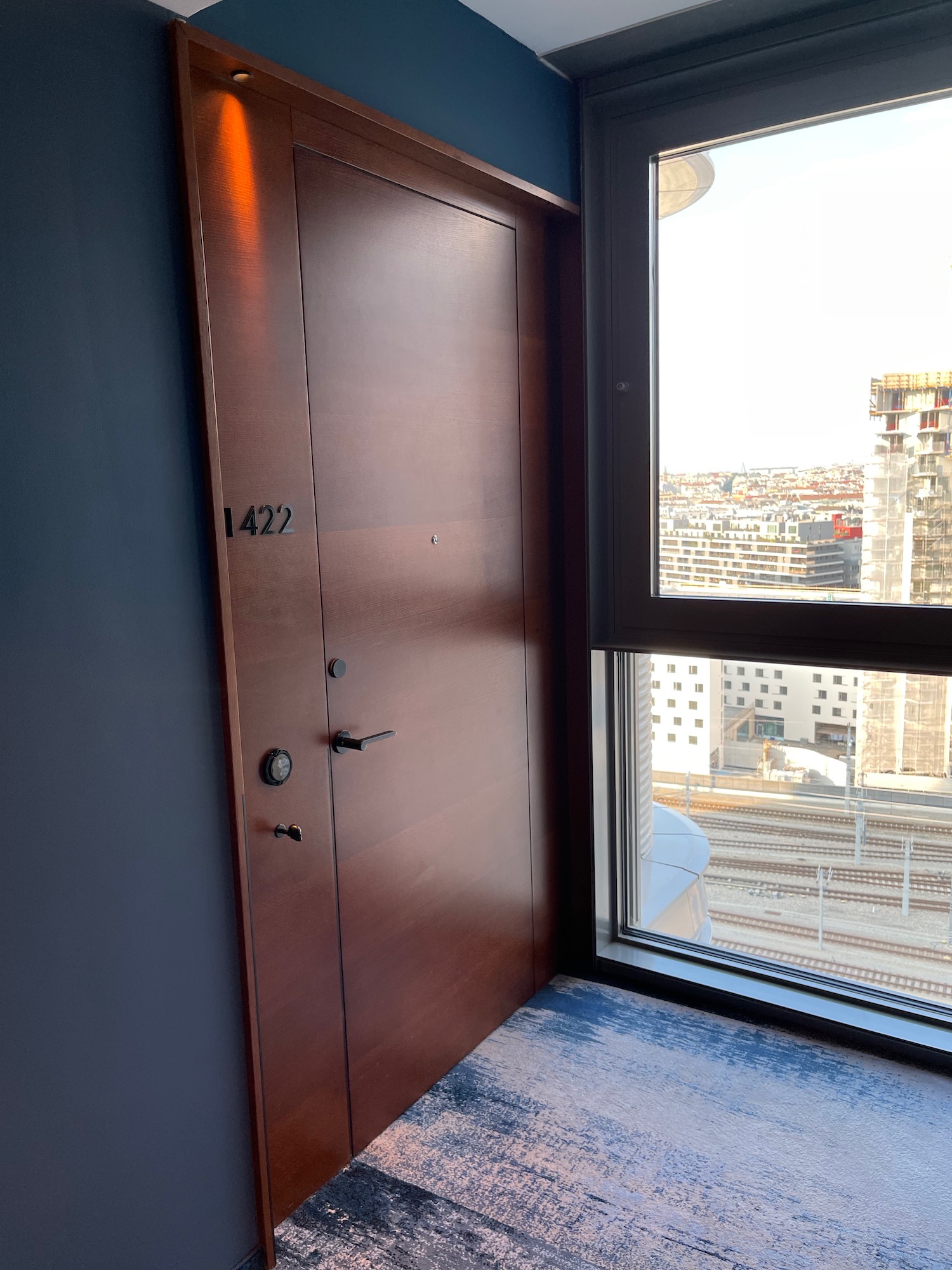 a door in a room with a window and a city view