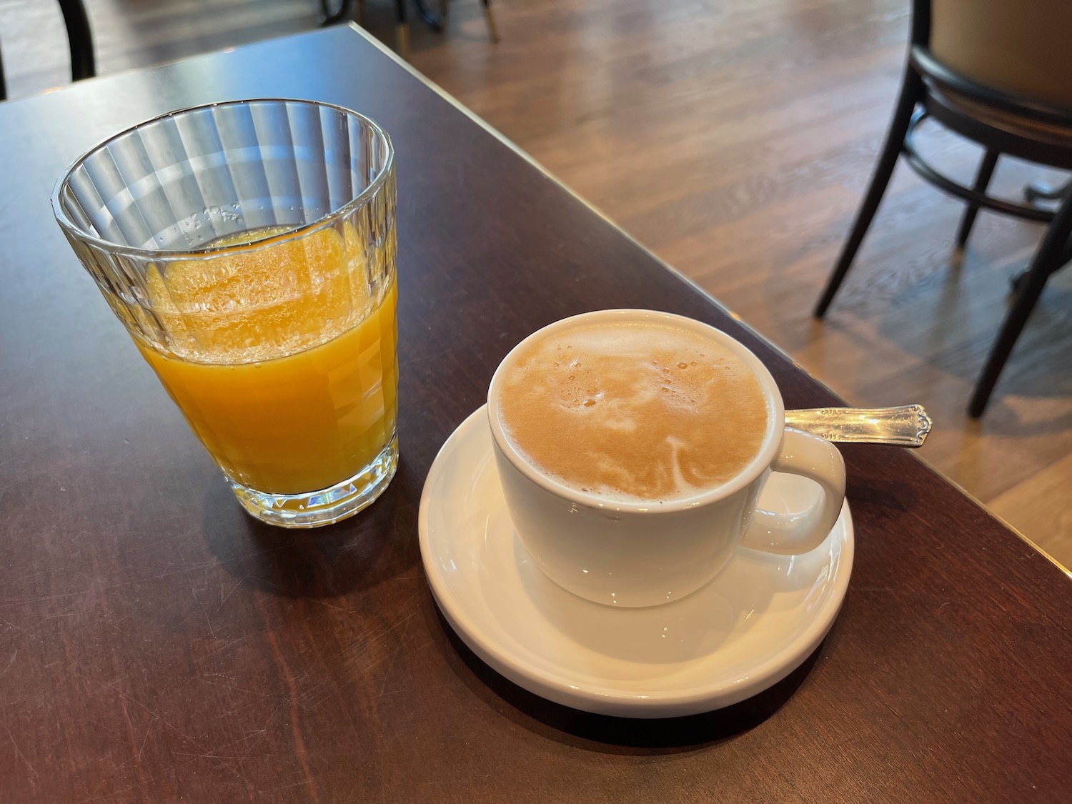 a cup of coffee and a glass of orange juice on a table