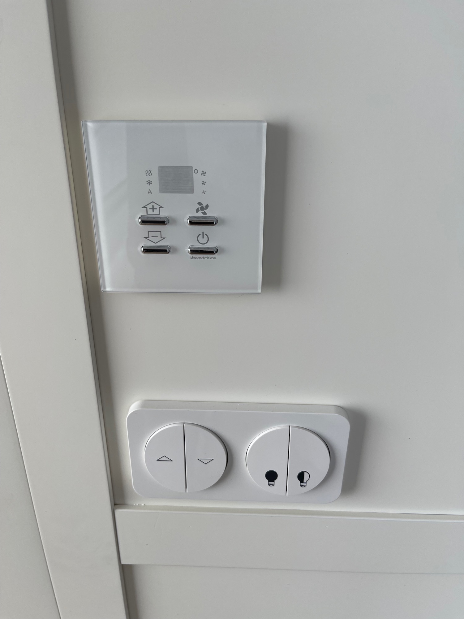 a white wall with a square panel and switches