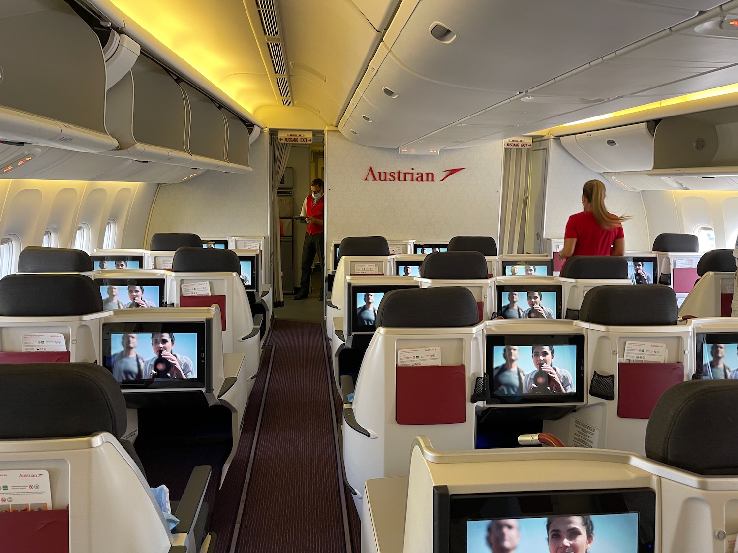 a row of seats with monitors on the side of the plane