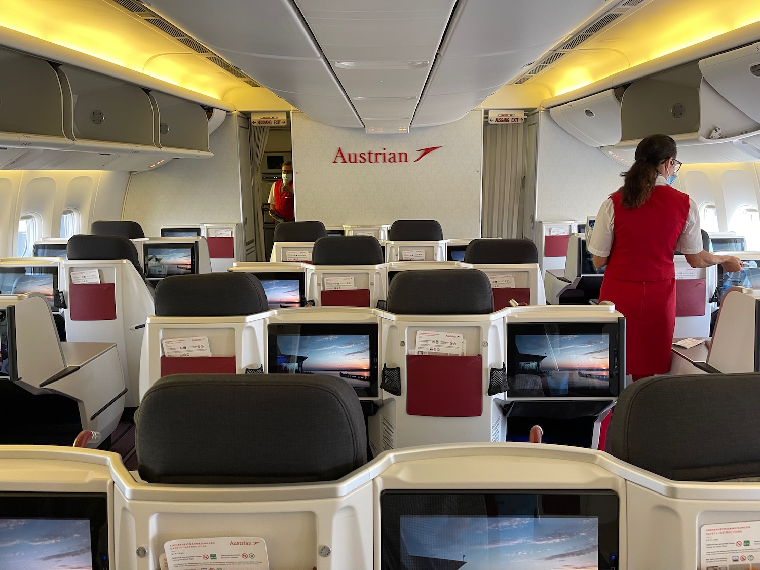 a woman in a red uniform standing in an airplane