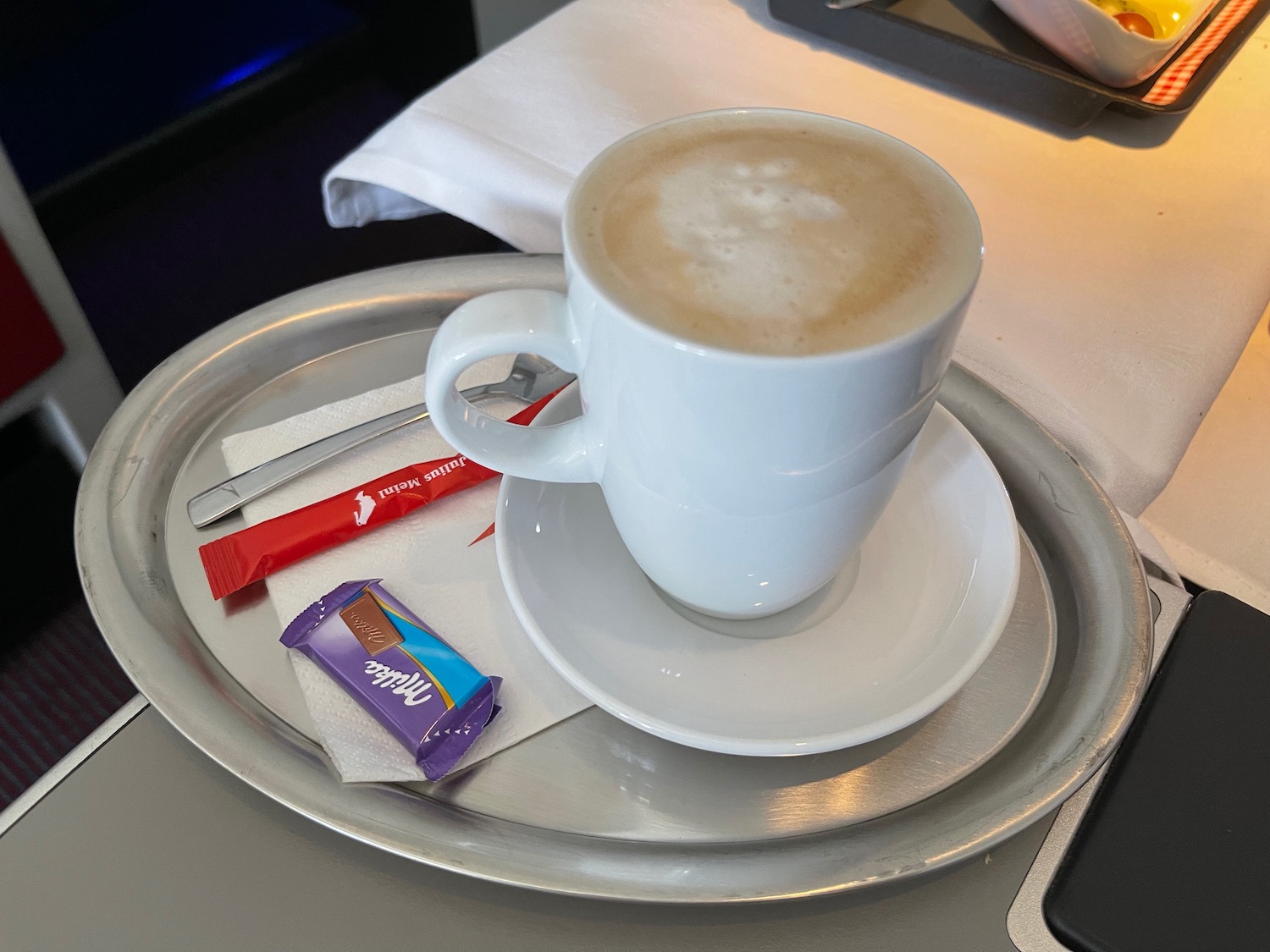 a cup of coffee and candy on a tray