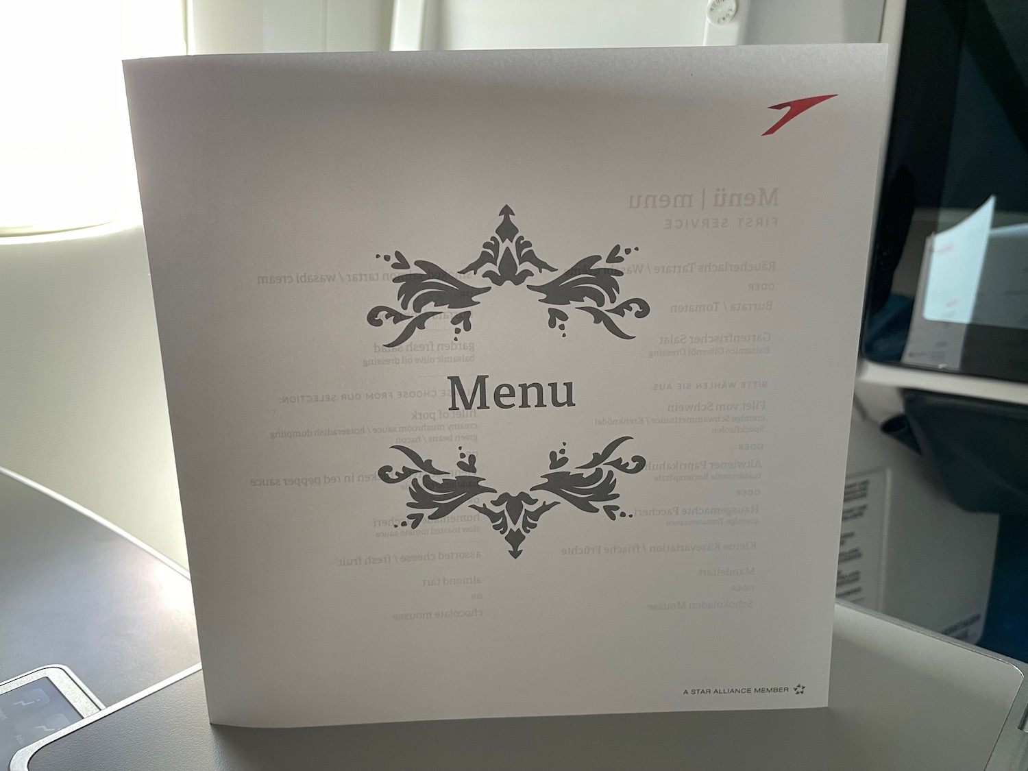 a white menu with black text and a red arrow