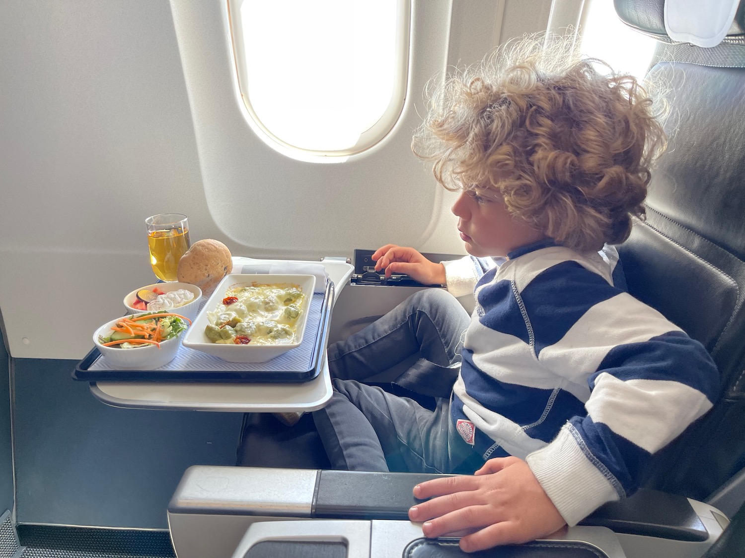 a child sitting in a chair with food on the table