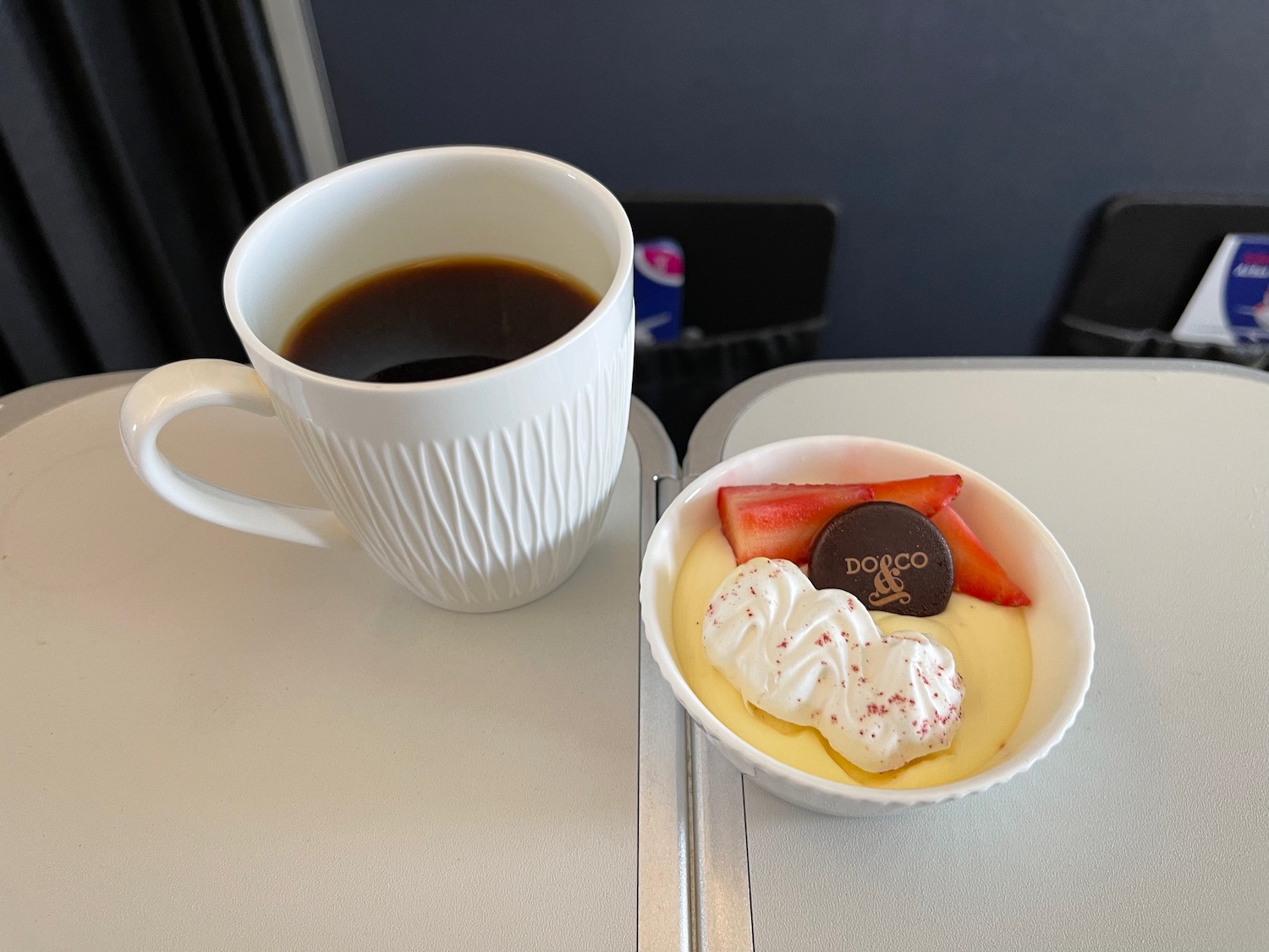 a cup of coffee next to a dessert