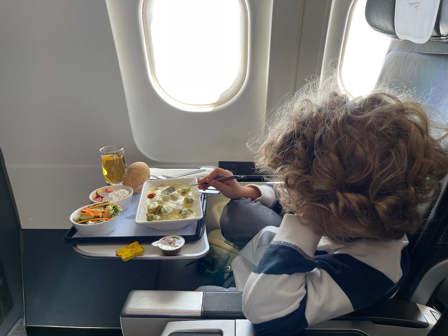 a child eating food on an airplane