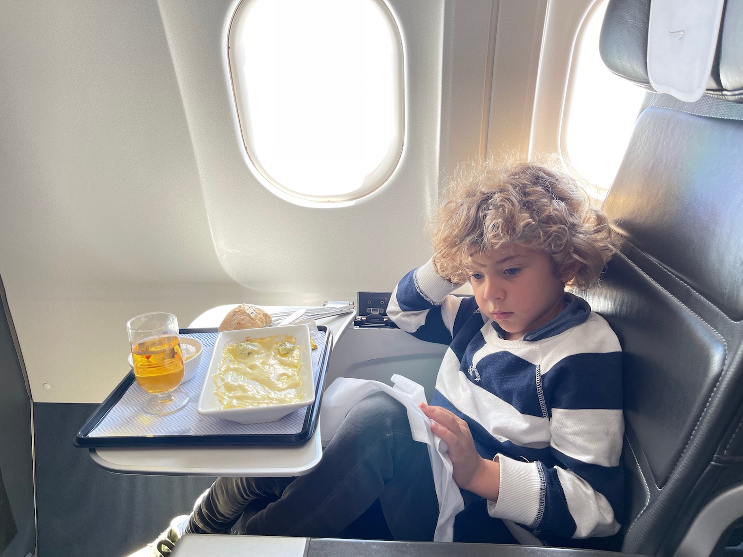 a child sitting in a chair on an airplane