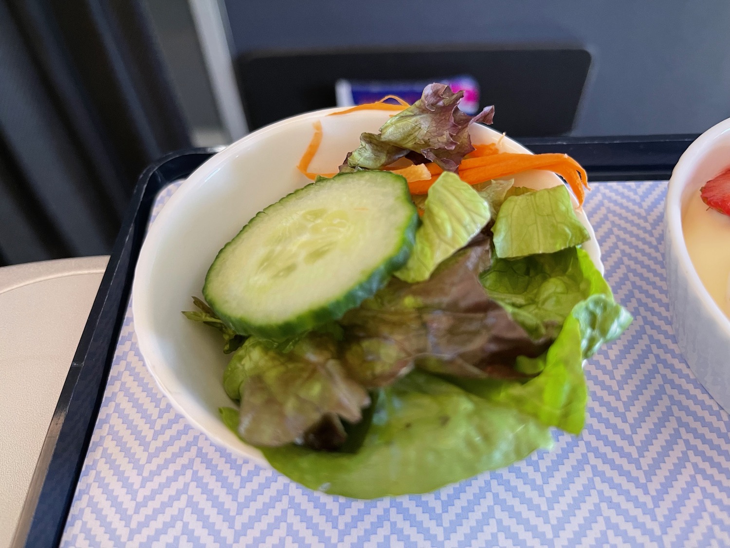 a bowl of salad with cucumber and carrots