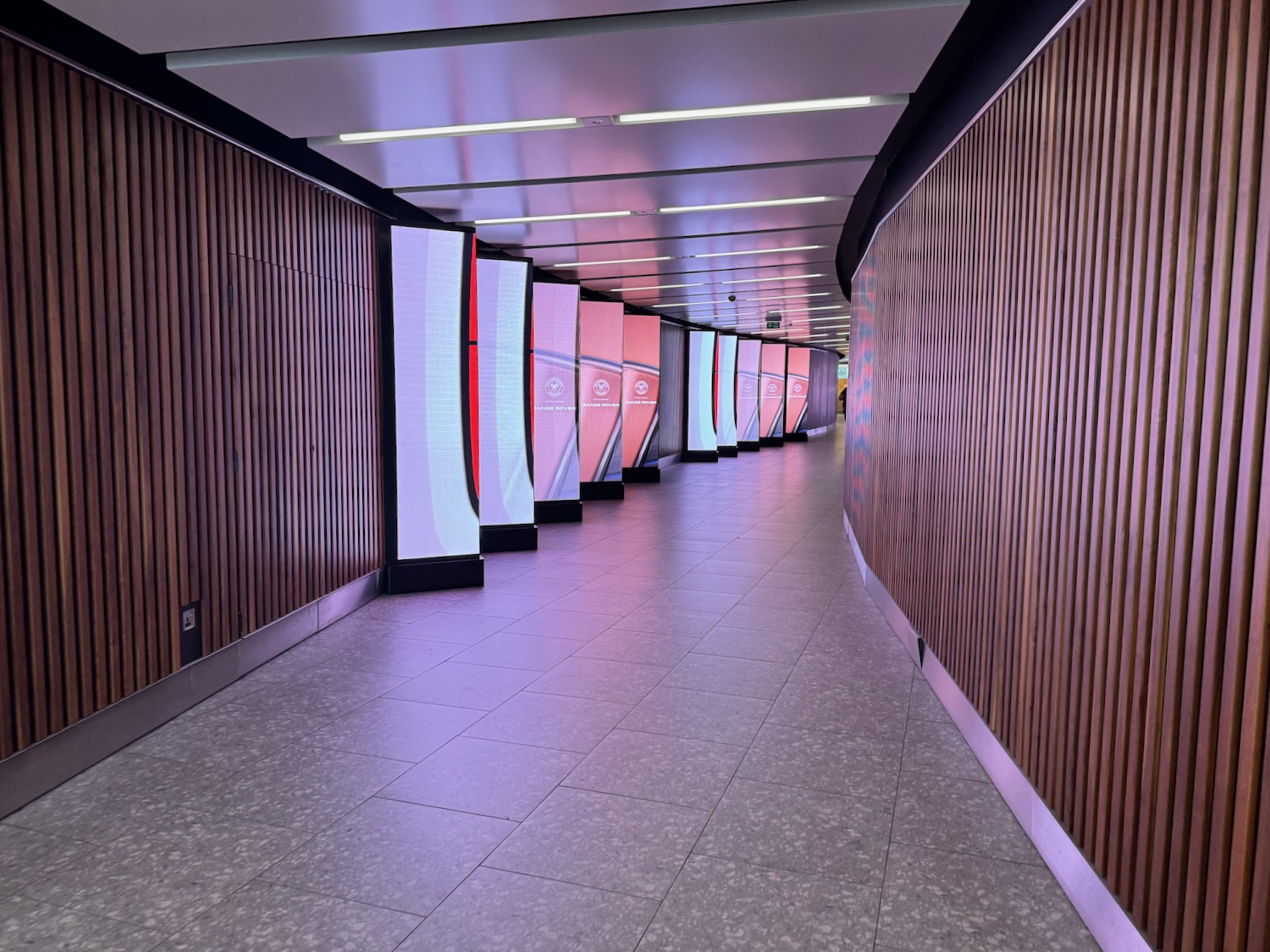 a long hallway with a row of colorful screens