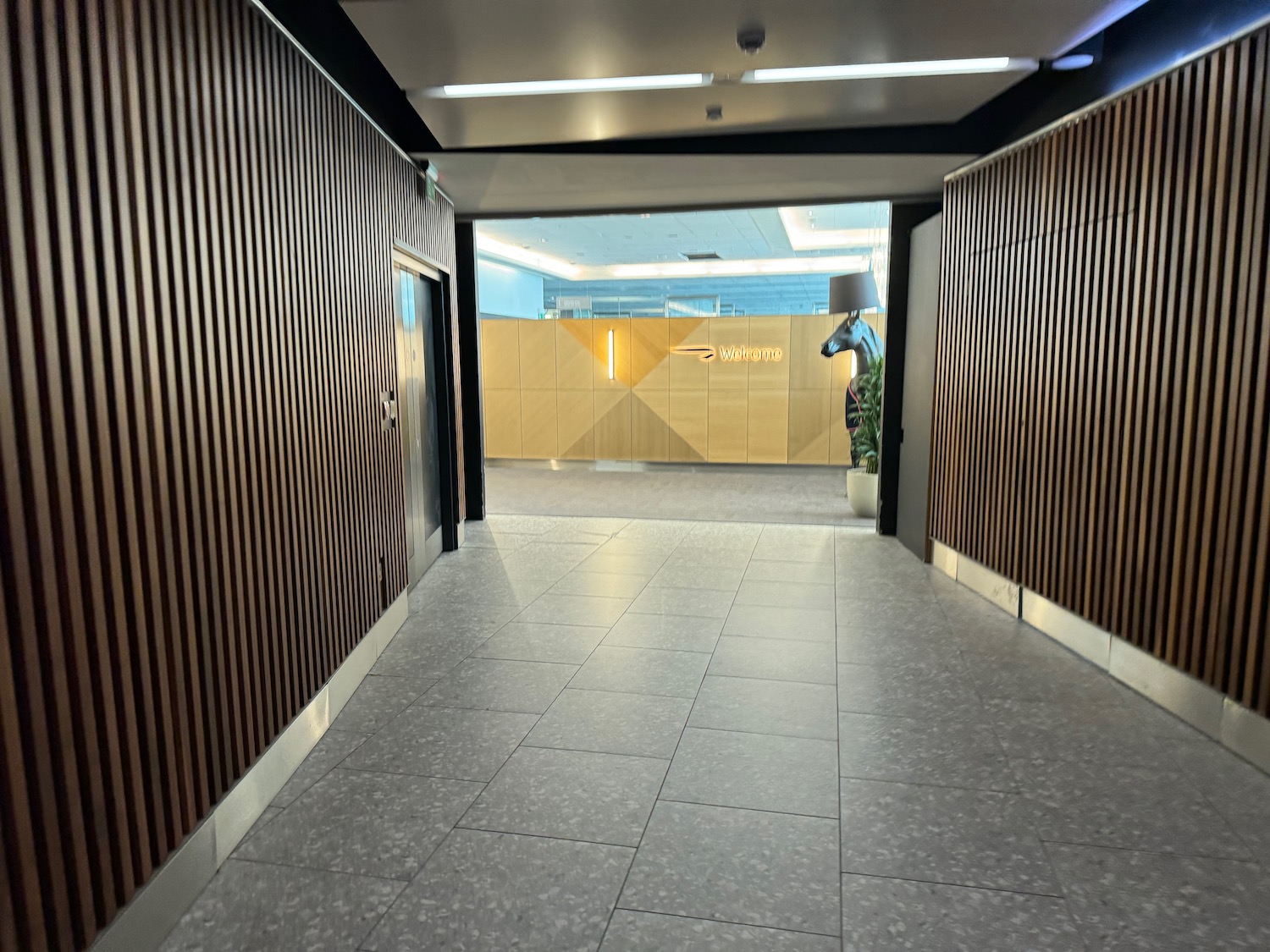 a hallway with wood panels and a lamp