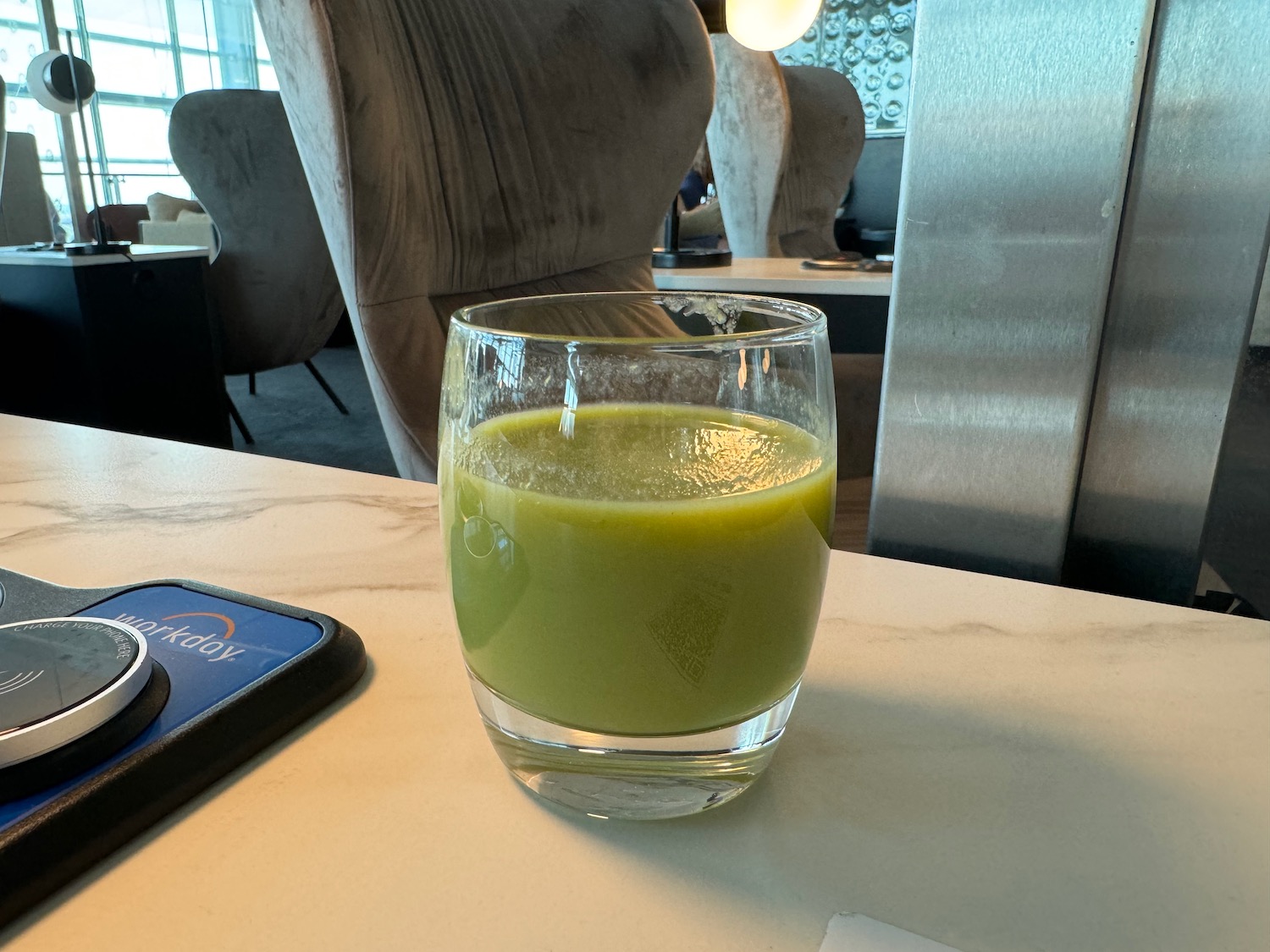 a glass of green liquid on a table