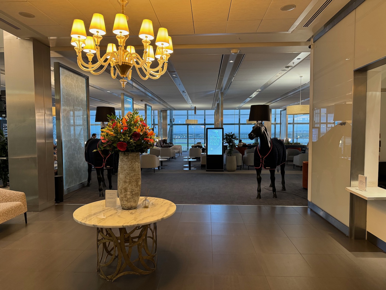 a room with a horse statue and a vase of flowers