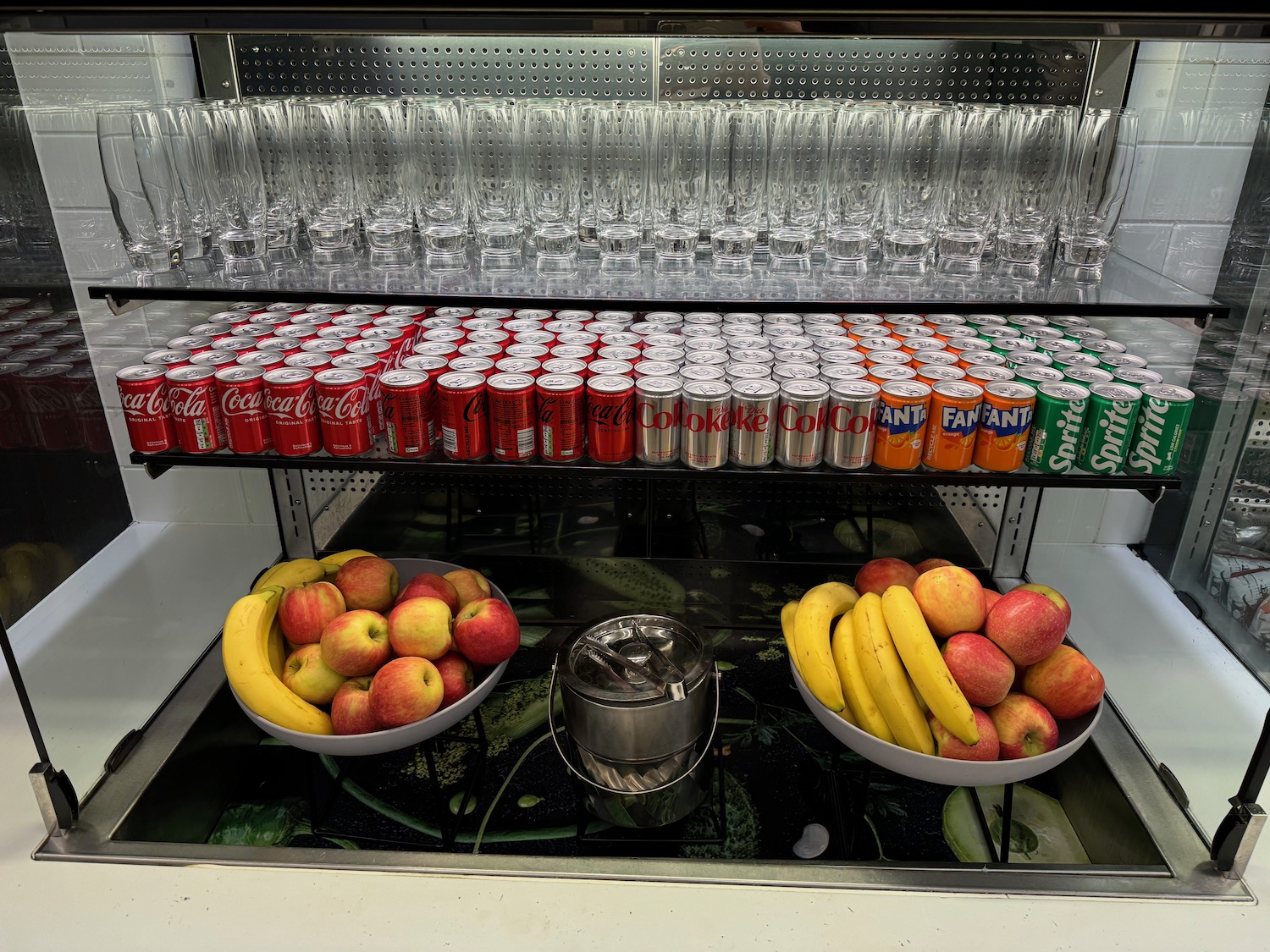 a shelf with fruit and cans of soda