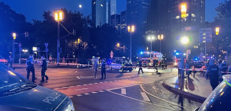 a group of police officers at a road with cars and lights