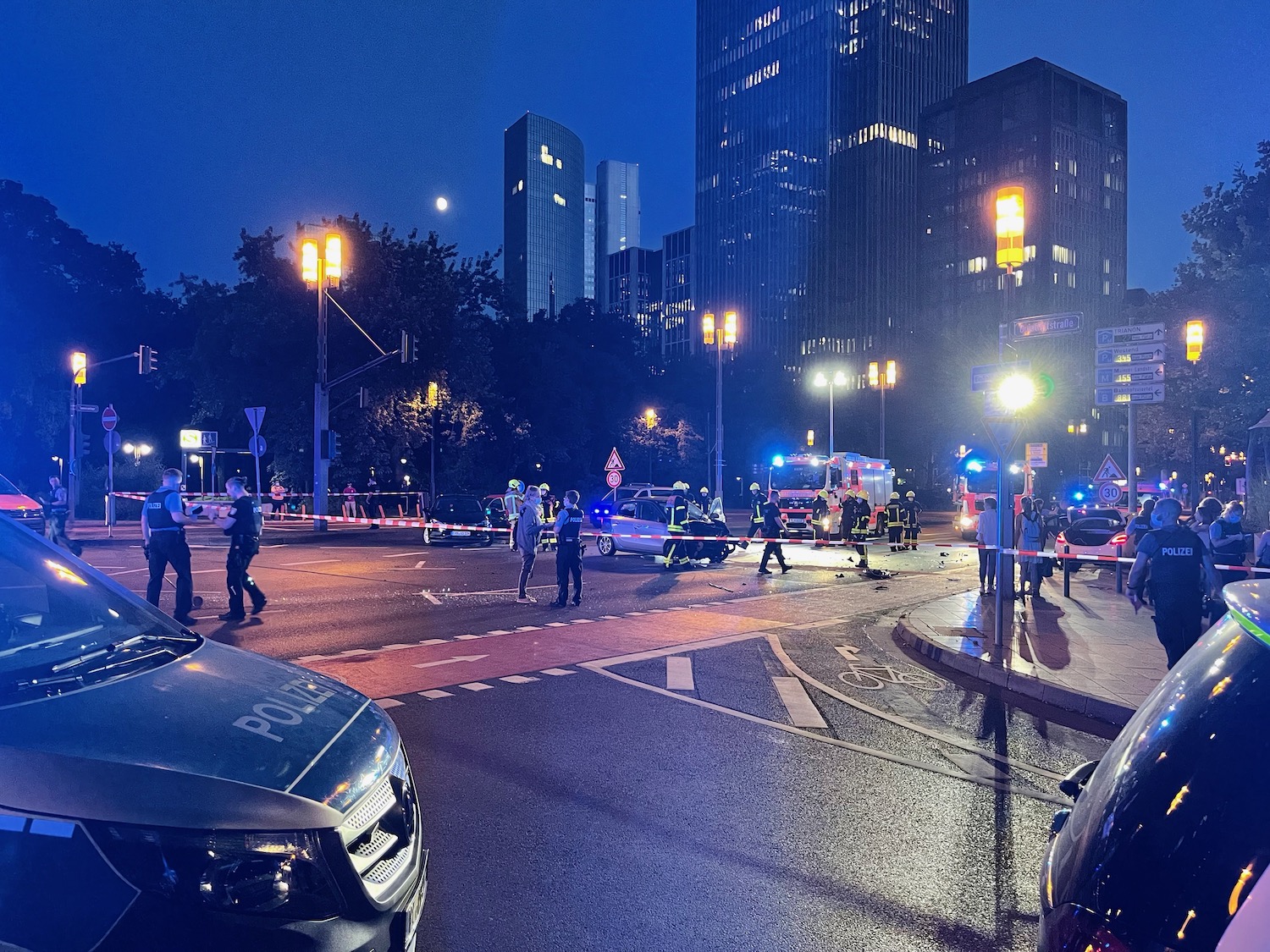 a group of police officers at a road with cars and lights