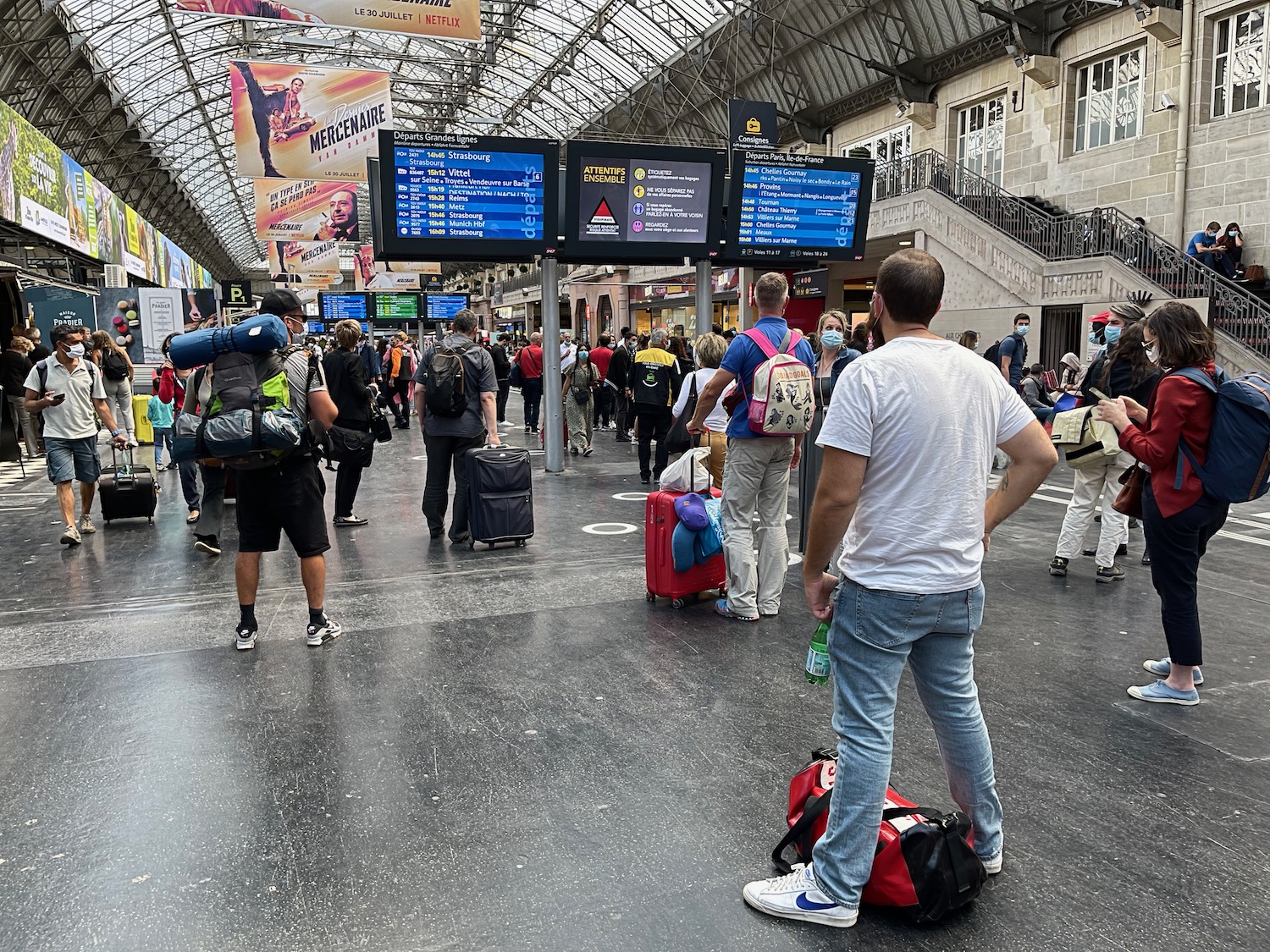 a group of people in a train station with Buekorps Museum in the background