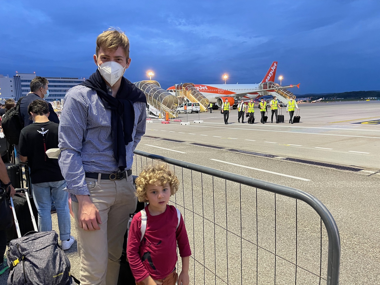 a man and child standing in front of an airplane