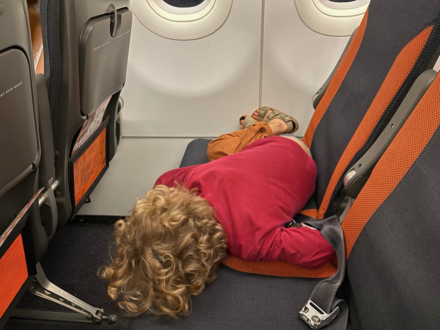 a child sleeping in an airplane seat