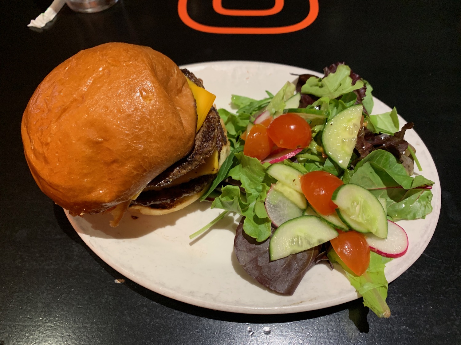 a burger and salad on a plate