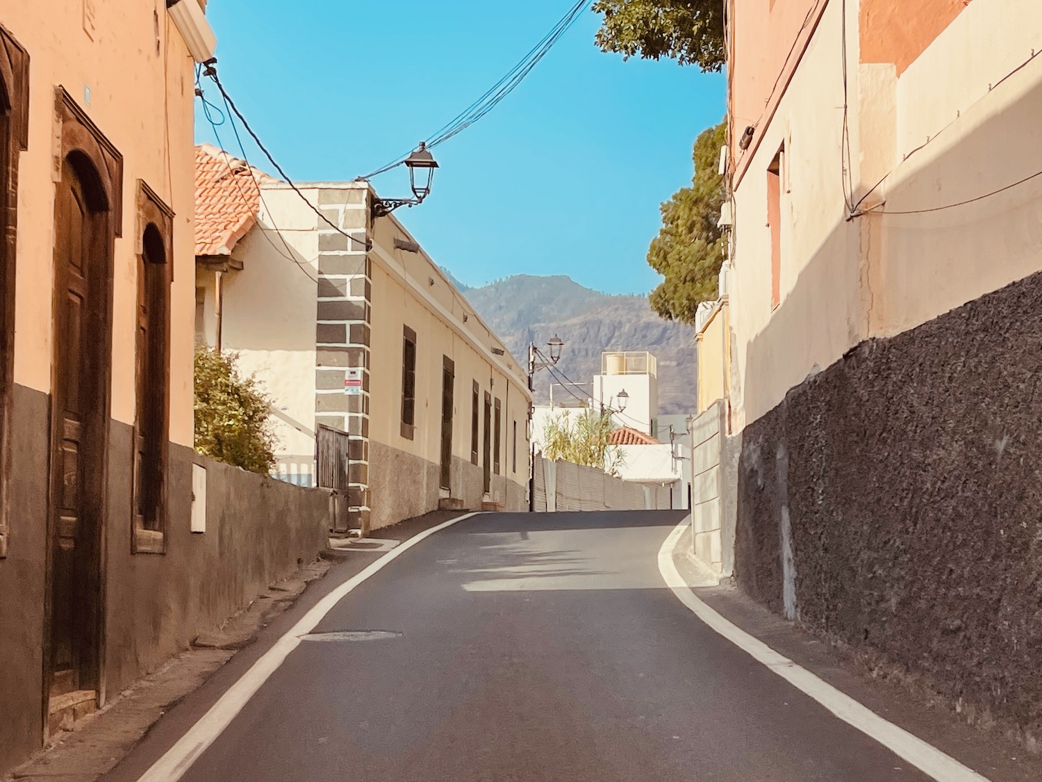 a street with buildings and a mountain in the background