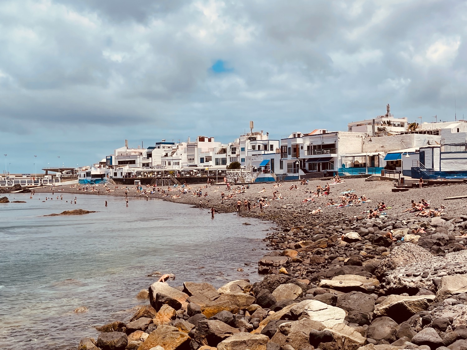 a beach with buildings and rocks