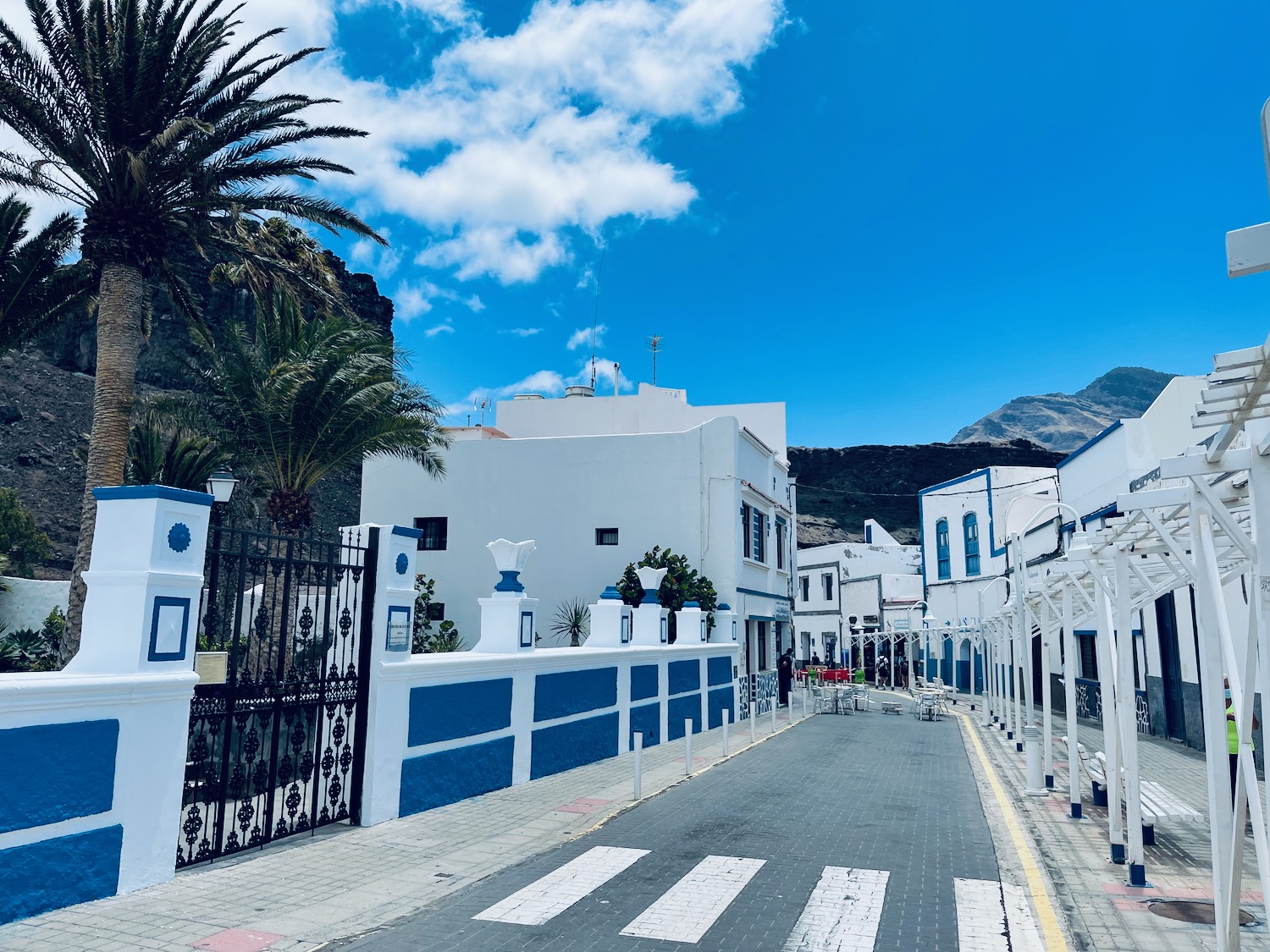 a street with white buildings and palm trees