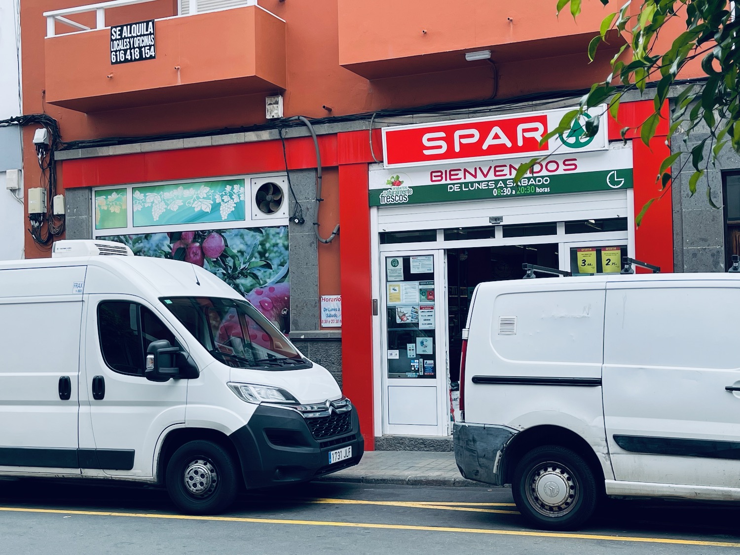 two white vans parked in front of a store