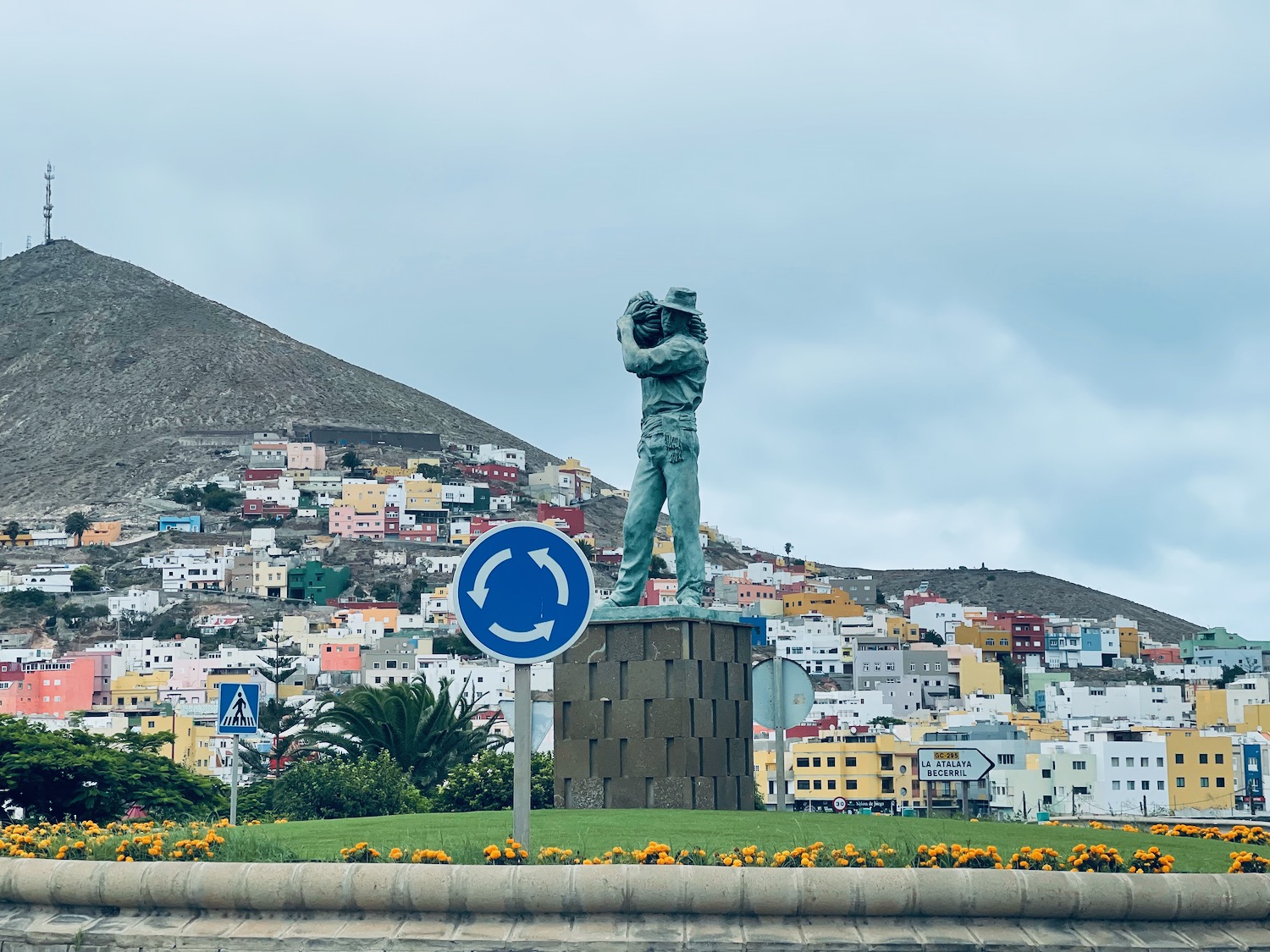 a statue of a man on a pedestal in front of a city