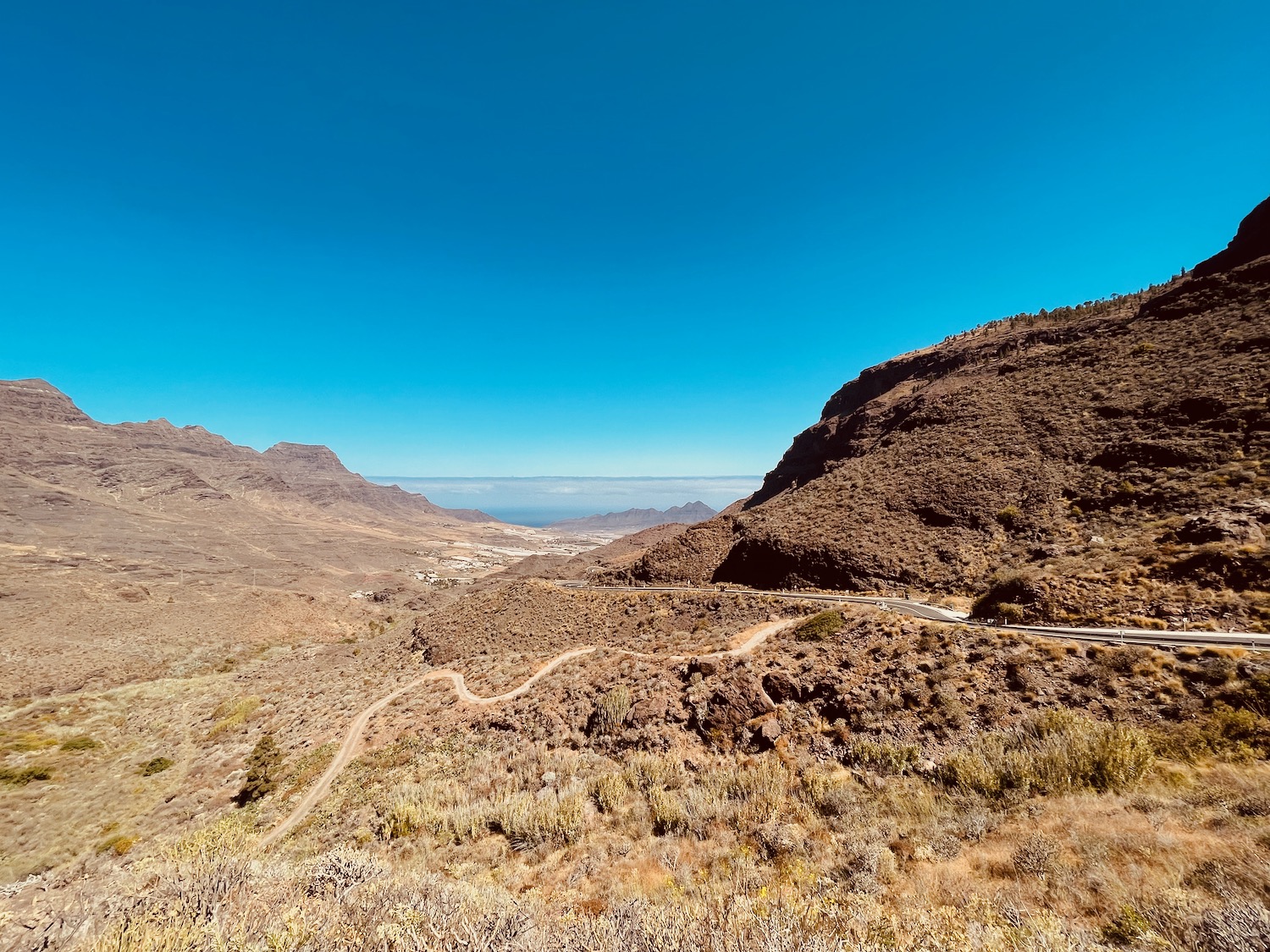 a dirt road through a valley