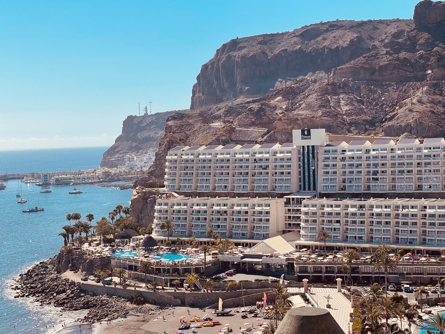 a large hotel on a rocky cliff by the water