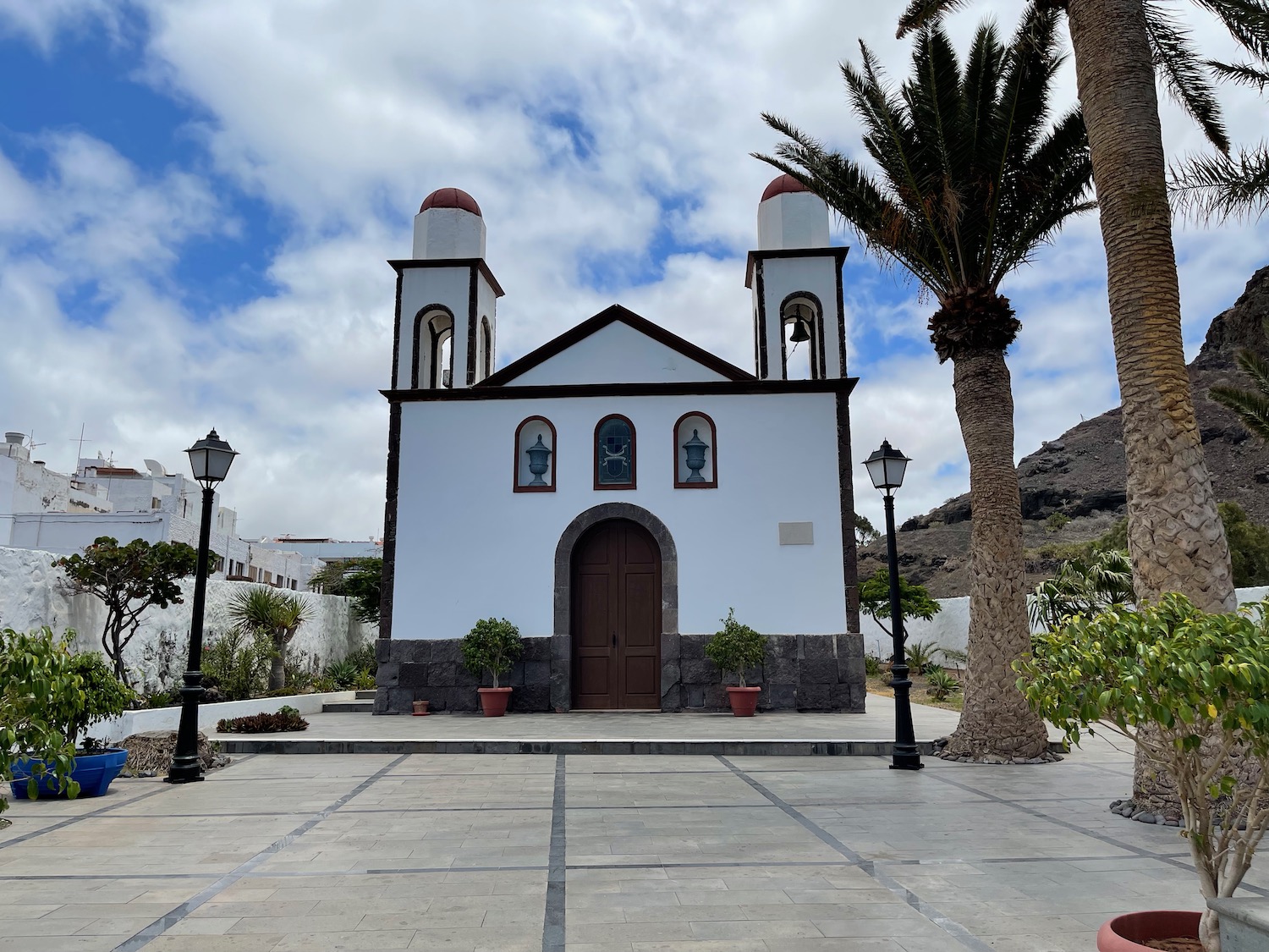 a white building with two towers and a palm tree